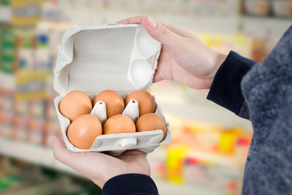 Man Holding Egg Carton In a Supermarket